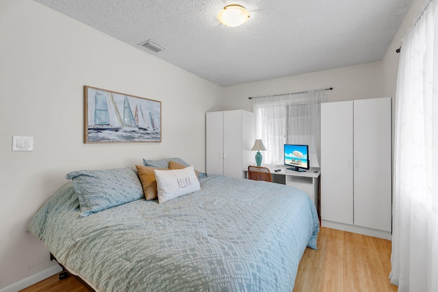 1519 Johnson St, Key West, FL 33040 - bedroom featuring a textured ceiling and light hardwood / wood-style flooring