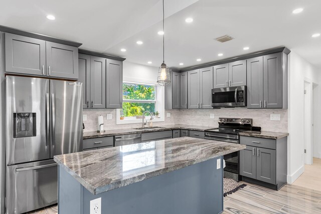 1519 Johnson St, Key West, FL 33040 - kitchen with light stone counters, sink, decorative light fixtures, and appliances with stainless steel finishes