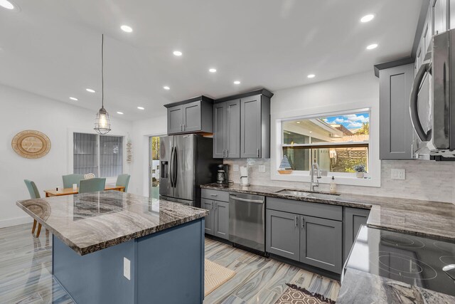 1519 Johnson St, Key West, FL 33040 - kitchen featuring appliances with stainless steel finishes, sink, gray cabinetry, dark stone counters, and hanging light fixtures