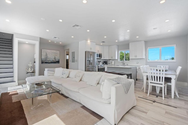 living room with stairway, recessed lighting, and baseboards