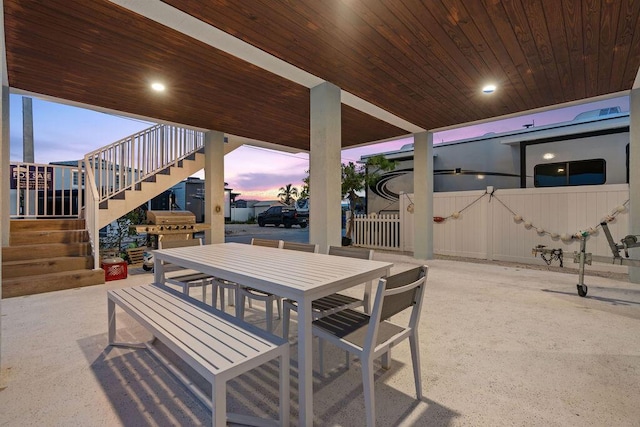 view of patio featuring stairway, outdoor dining area, and fence