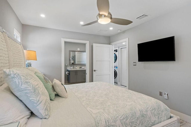 bedroom featuring stacked washing machine and dryer, recessed lighting, a spacious closet, ensuite bath, and a ceiling fan