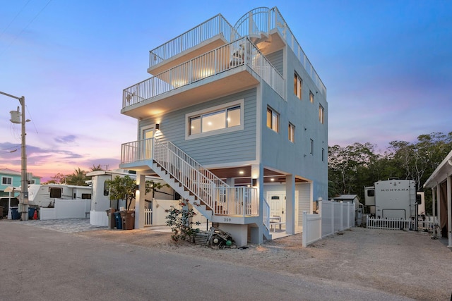 view of front of property with a balcony, fence, and stairway