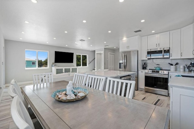 dining space with recessed lighting and light marble finish flooring