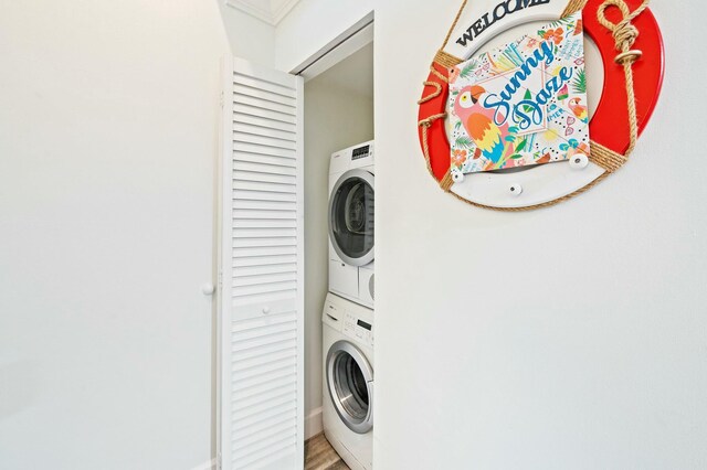 laundry room with laundry area, stacked washing maching and dryer, and wood finished floors