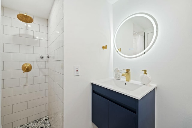 bathroom featuring a tile shower and vanity