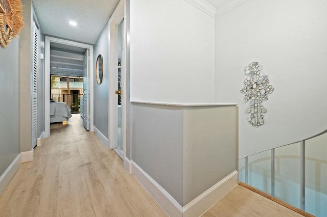 corridor with baseboards, wood finished floors, and ornamental molding