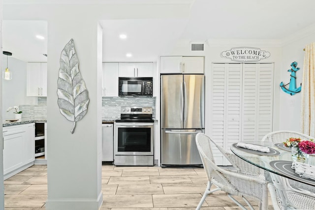 kitchen with white cabinetry, visible vents, stainless steel appliances, and wood finish floors