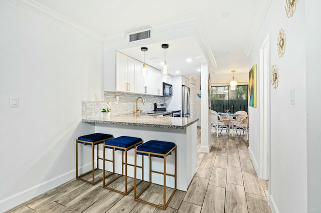 kitchen with tasteful backsplash, visible vents, wood tiled floor, stainless steel electric range, and black microwave