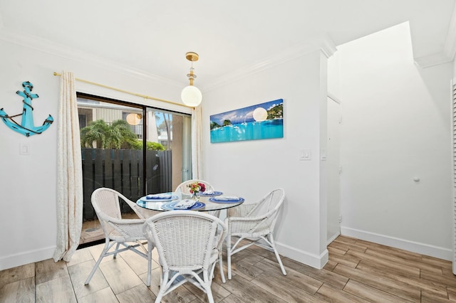 dining room featuring baseboards, ornamental molding, and wood finish floors