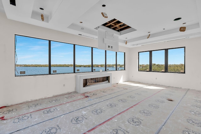 25 Mutiny Pl, Key Largo, FL 33037 - unfurnished living room with a tray ceiling, a fireplace, and a water view