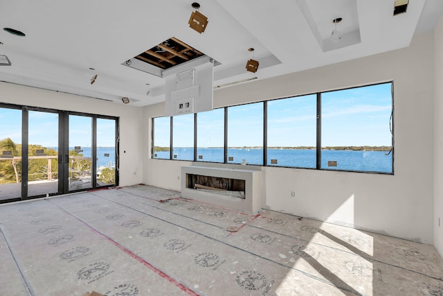 25 Mutiny Pl, Key Largo, FL 33037 - unfurnished living room featuring a water view, a fireplace, and a raised ceiling