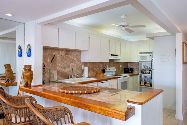 kitchen featuring sink, white appliances, kitchen peninsula, and white cabinets