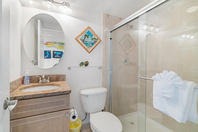 bathroom with walk in shower, vanity, and toilet