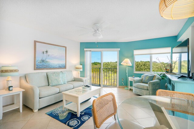 tiled living room featuring ceiling fan, plenty of natural light, and a textured ceiling