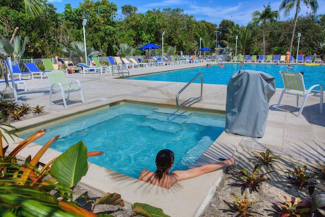 view of swimming pool featuring a grill and a patio area