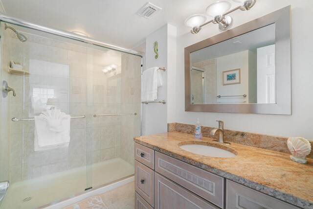 bathroom featuring walk in shower, vanity, and tile patterned flooring