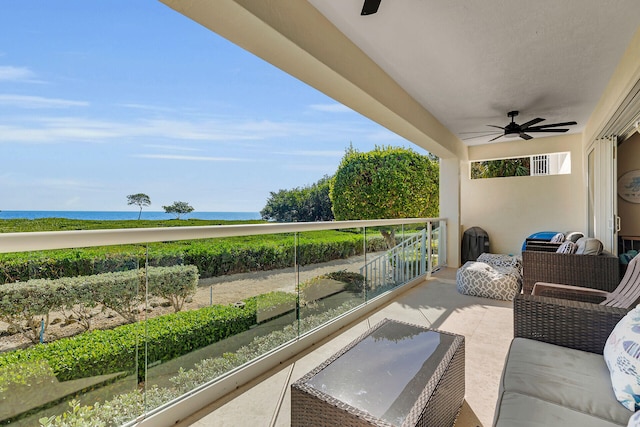 view of patio with a water view, ceiling fan, and a balcony