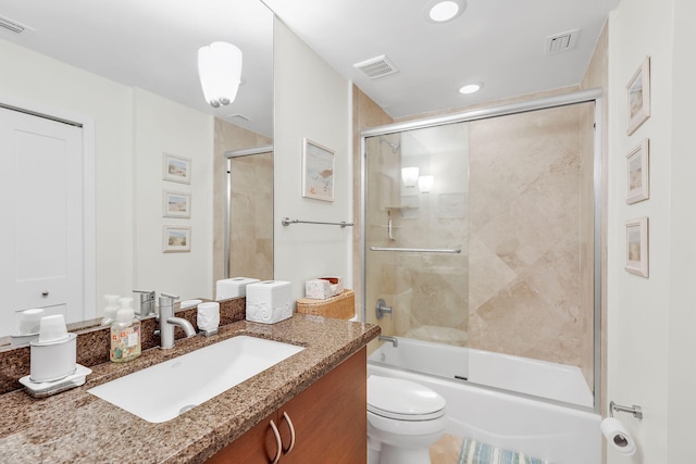 full bathroom with enclosed tub / shower combo, vanity, and toilet