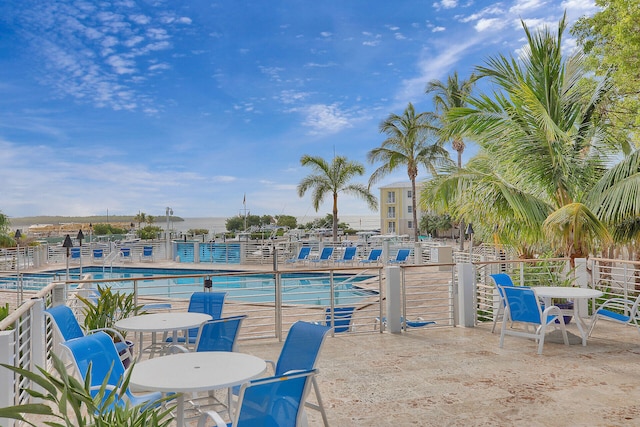 view of swimming pool featuring a patio and a water view