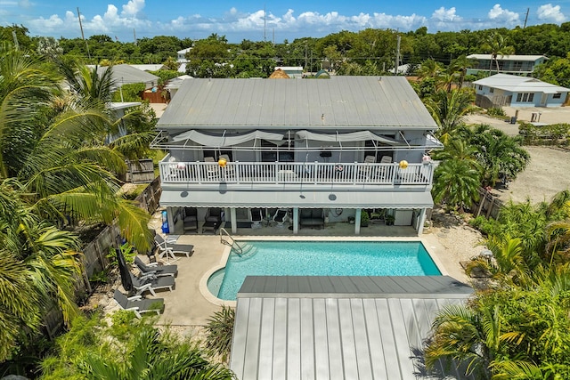 rear view of property with a pool side deck and a patio area