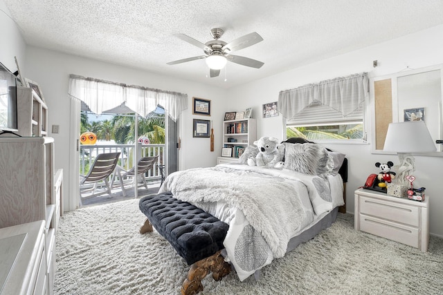 bedroom with ceiling fan, access to outside, light colored carpet, and a textured ceiling