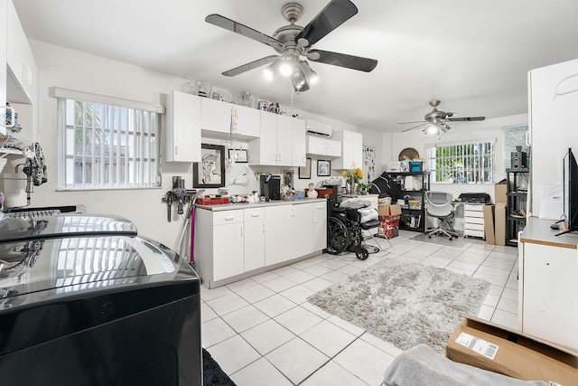 kitchen featuring white cabinetry, washer / dryer, light tile patterned floors, and ceiling fan