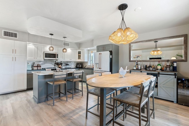 dining space with visible vents and light wood finished floors