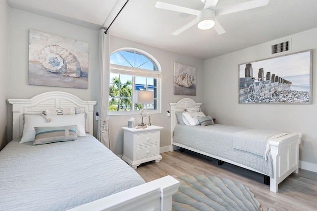 bedroom with baseboards, ceiling fan, light wood-style flooring, and visible vents