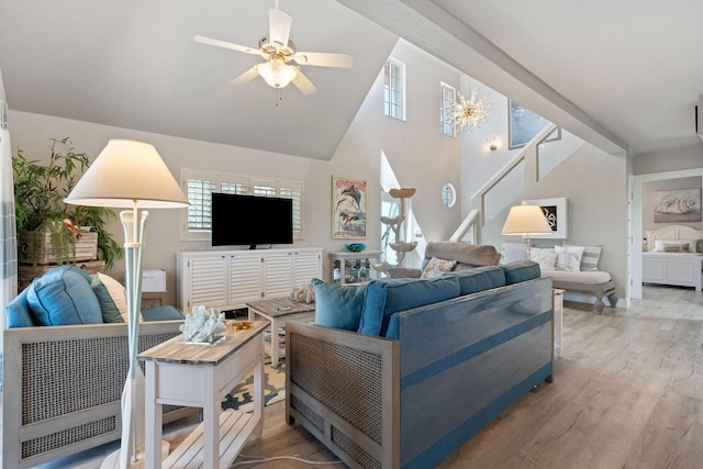 living area featuring stairway, ceiling fan, light wood-type flooring, and a healthy amount of sunlight
