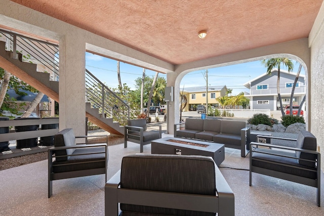 view of patio / terrace featuring an outdoor living space with a fire pit and stairway