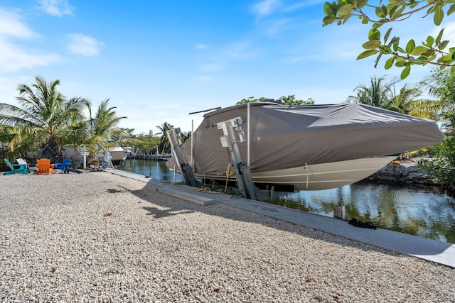 view of property exterior with a boat dock, boat lift, and a water view