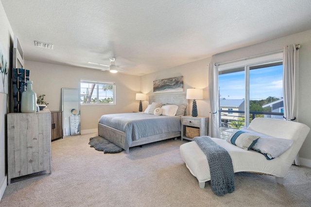 bedroom featuring a ceiling fan, a textured ceiling, visible vents, and carpet