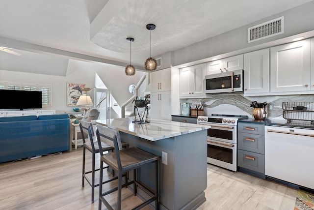 kitchen featuring visible vents, dishwasher, double oven range, and light wood-type flooring
