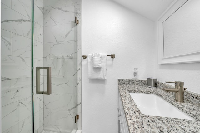 bathroom with vanity and a shower with shower door