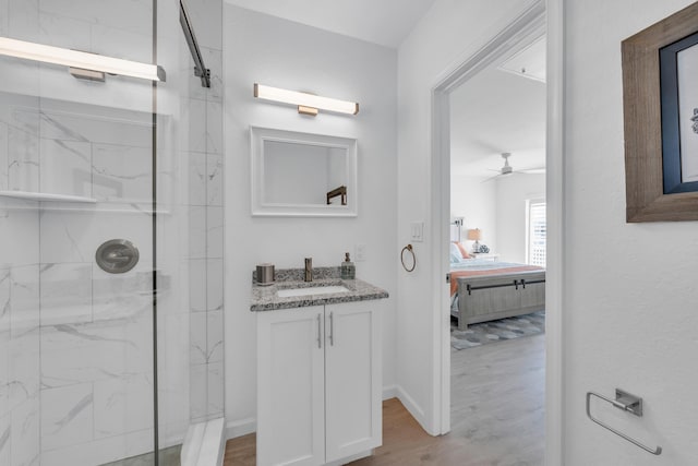 bathroom featuring ceiling fan, vanity, a shower with door, and hardwood / wood-style floors