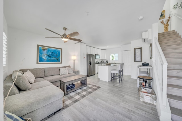 living room featuring ceiling fan and light wood-type flooring