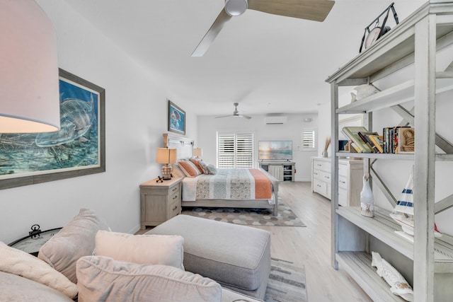 bedroom with light hardwood / wood-style flooring, an AC wall unit, and ceiling fan