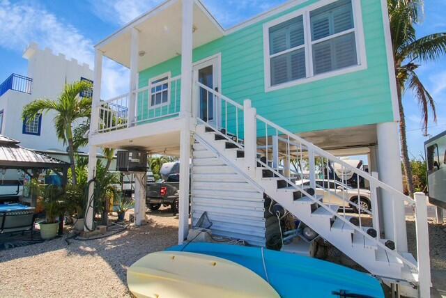 back of house featuring stairs and a carport