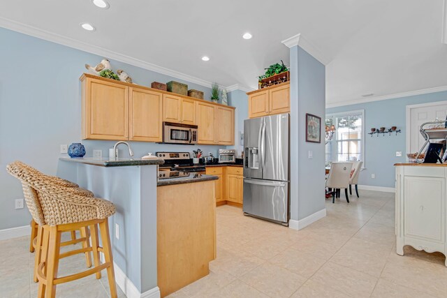 kitchen with crown molding, a breakfast bar area, appliances with stainless steel finishes, light brown cabinetry, and kitchen peninsula