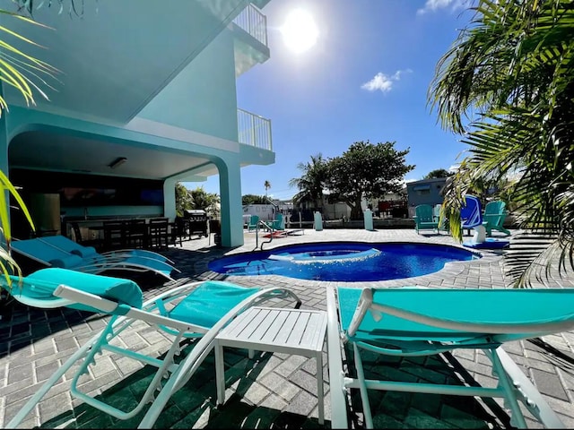 view of pool with fence, a fenced in pool, an in ground hot tub, a patio area, and outdoor dry bar