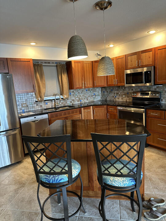 kitchen with stainless steel appliances, sink, pendant lighting, and decorative backsplash