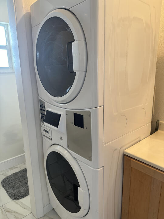 laundry area featuring stacked washing maching and dryer