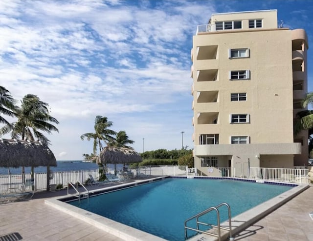 view of pool with a patio area and a water view