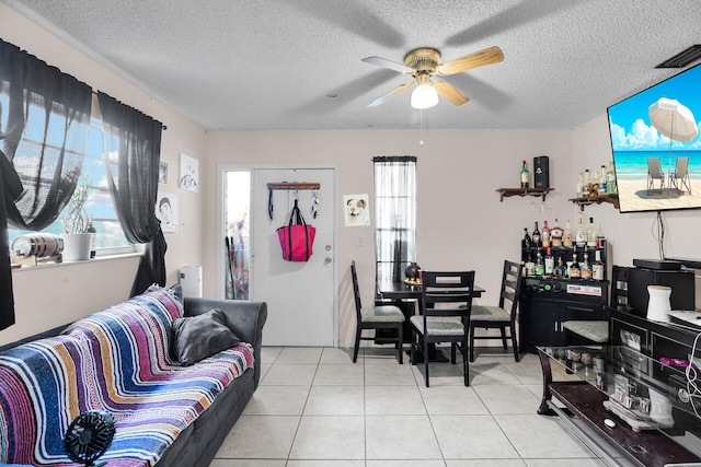 tiled living room featuring a textured ceiling and ceiling fan