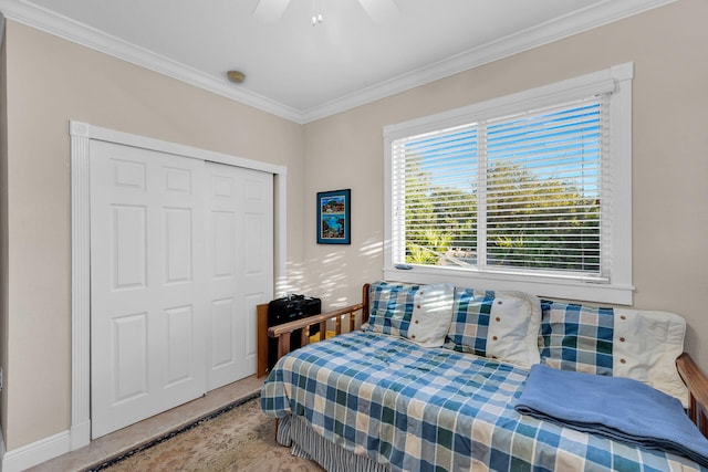 tiled bedroom featuring ceiling fan, a closet, and crown molding