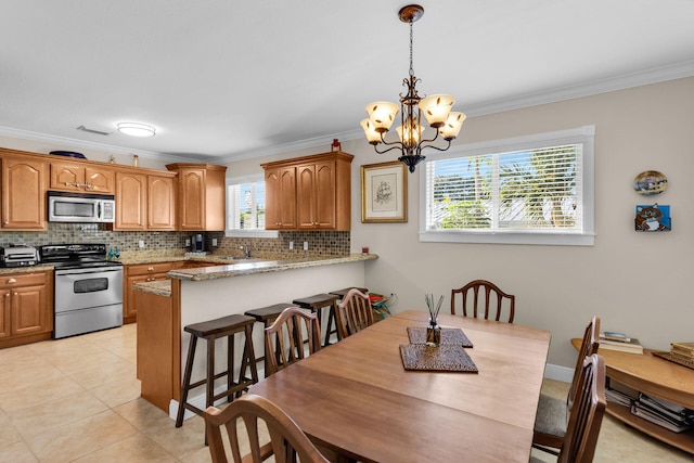 dining area featuring an inviting chandelier, light tile patterned floors, ornamental molding, and a wealth of natural light