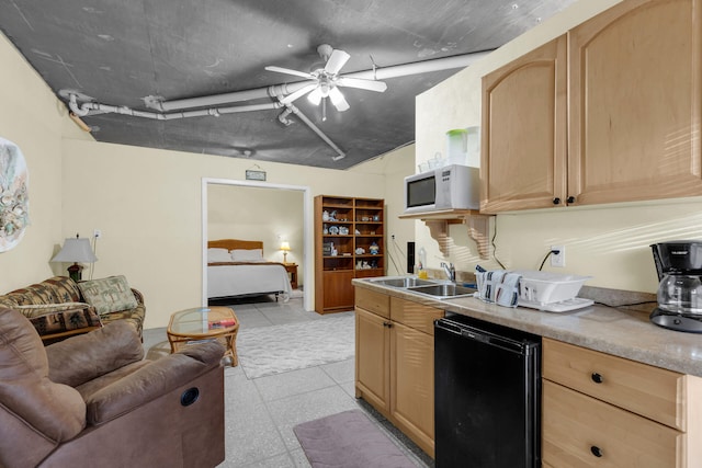 kitchen with white microwave, a ceiling fan, a sink, and light brown cabinetry