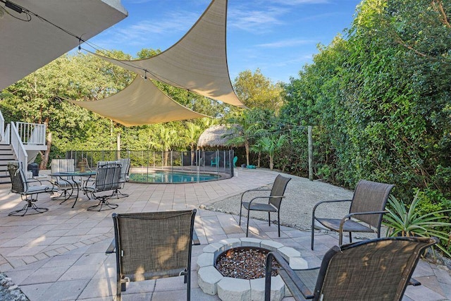 view of patio with a fire pit, fence, and a fenced in pool