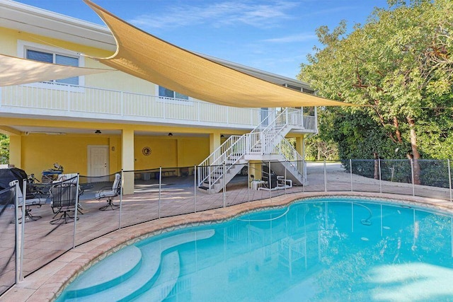 view of swimming pool featuring stairs, a fenced in pool, fence, and a patio